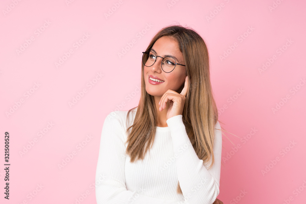 Young blonde woman over isolated pink background with glasses Young blonde woman over isolated pink background with glasses