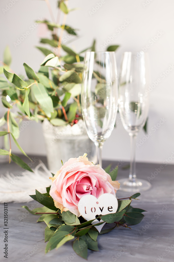 Composition with glass for champagne. Flowers and hearts on grey concrete background. Composition with glass for champagne. Flowers and hearts on grey concrete background.