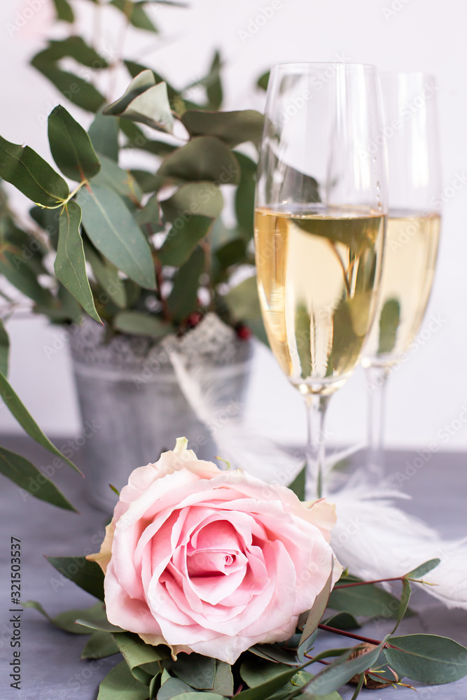Composition with glasses of vine and flowers on grey concrete background.