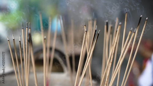 Incense sticks on joss stick pot laced are burning and smoke use for pay respect to the Buddha..