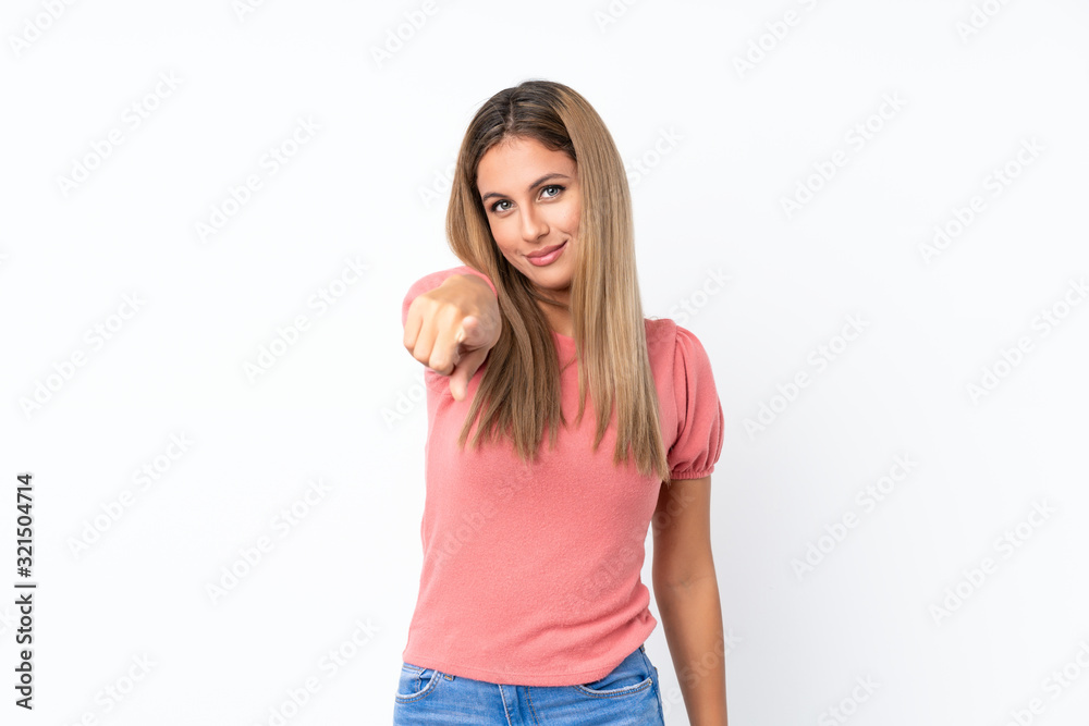 Young blonde woman over isolated white background points finger at you with a confident expression Young blonde woman over isolated white background points finger at you with a confident expression