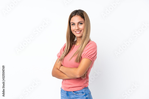 Young blonde woman over isolated white background with arms crossed and looking forward © luismolinero