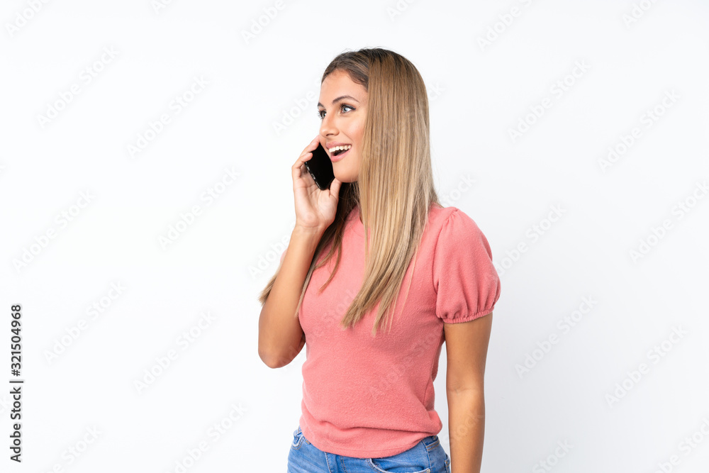 Young blonde woman over isolated white background keeping a conversation with the mobile phone Young blonde woman over isolated white background keeping a conversation with the mobile phone