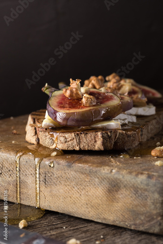 Figs. Sandwiches with figs, cheese, arugula, honey and nuts. toast with creamy yogurt and feta cheese spread, fresh figs with honey. Bruschetta with cheese and figs. Homemade. Everyday autumn kitchen.