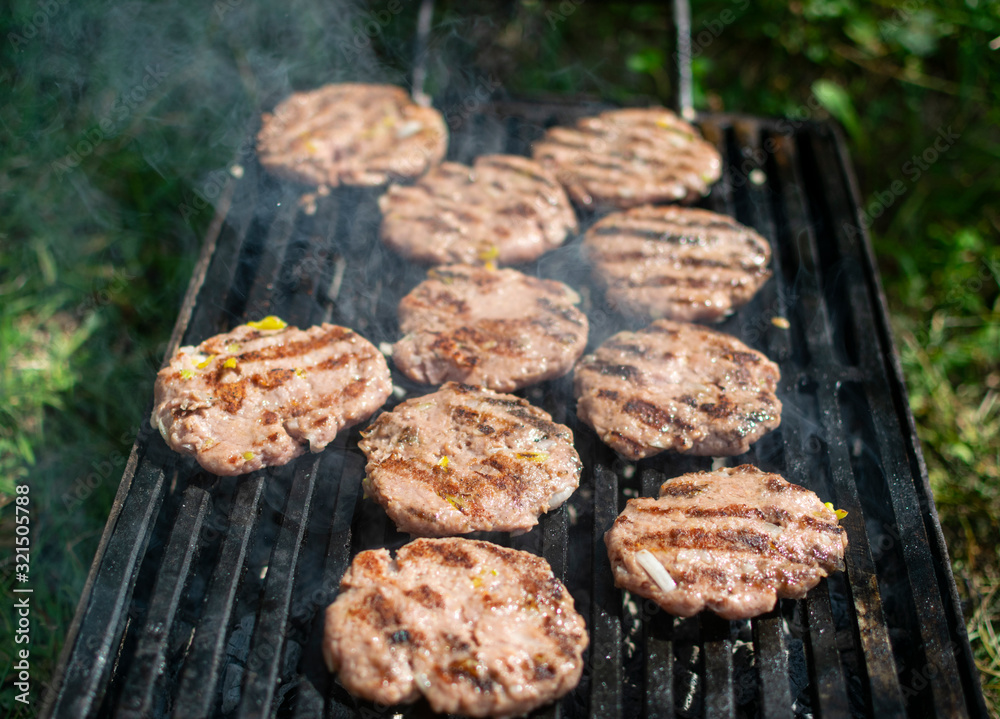 Summer barbecue. Fresh burgers on grill Summer barbecue. Fresh burgers on grill