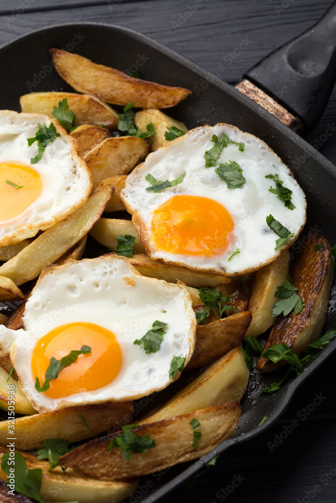 Breakfast in the pan. Fried potatoes with eggs in a skillet. Food bachelor. Cooked by a man. Hot and fresh. Homemade breakfast on black table. Fried eggs and sweet potato hash in cast iron skillet Fre Breakfast in the pan. Fried potatoes with eggs in a skillet. Food bachelor. Cooked by a man. Hot and fresh. Homemade breakfast on black table. Fried eggs and sweet potato hash in cast iron skillet Fre
