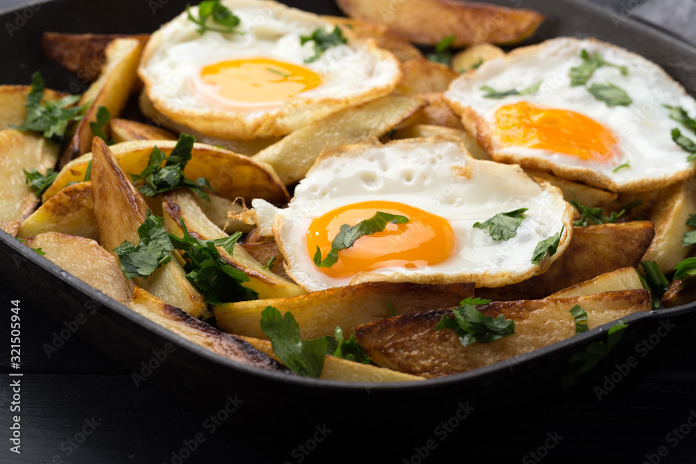 Breakfast in the pan. Fried potatoes with eggs in a skillet. Food bachelor. Cooked by a man. Hot and fresh. Homemade breakfast on black table. Fried eggs and sweet potato hash in cast iron skillet Fre Breakfast in the pan. Fried potatoes with eggs in a skillet. Food bachelor. Cooked by a man. Hot and fresh. Homemade breakfast on black table. Fried eggs and sweet potato hash in cast iron skillet Fre
