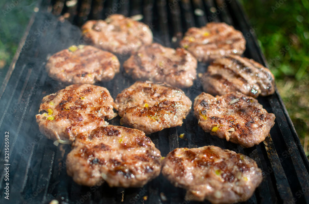Summer barbecue. Fresh burgers on grill