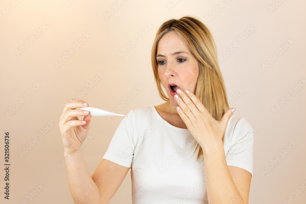 Woman looking at thermometer and is in shock Woman looking at thermometer and is in shock