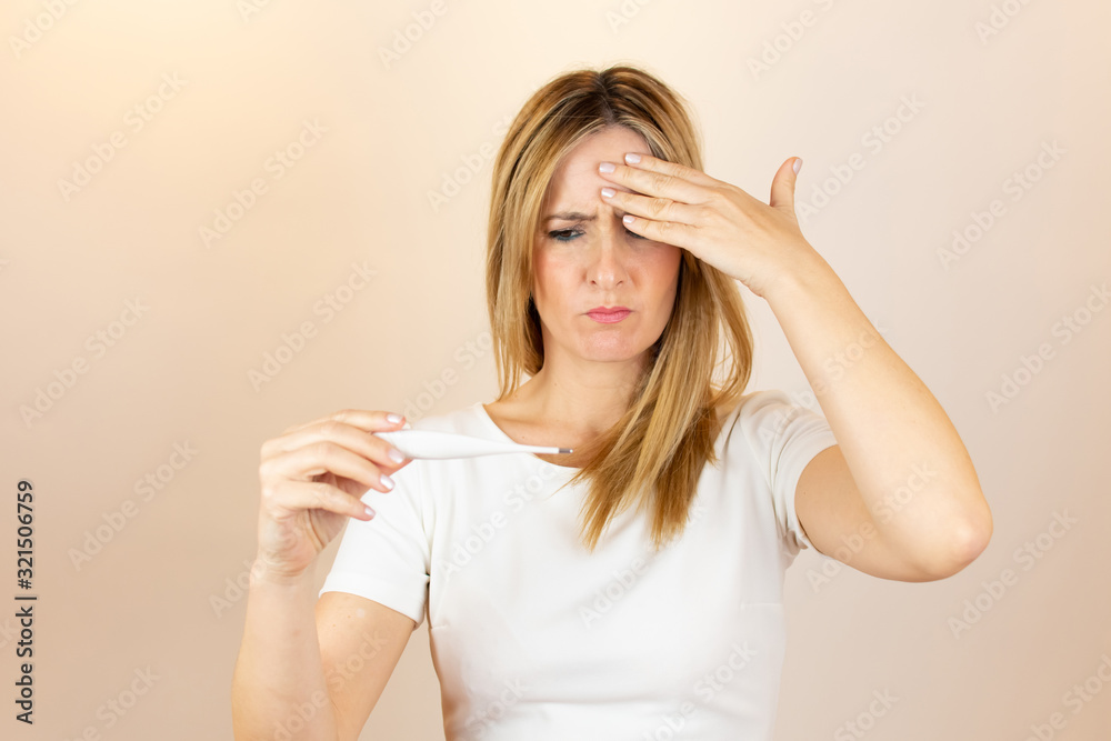 Woman looking at thermometer and is in shock Woman looking at thermometer and is in shock