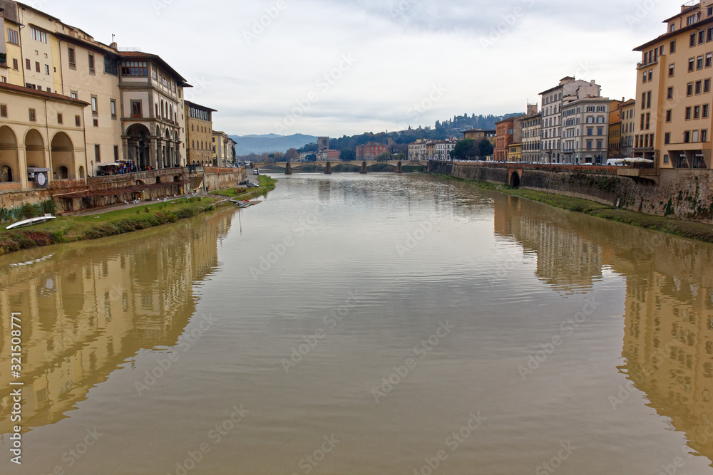 Florence Firenze arno river Italy during winter season. Showing cloudy sky. both coast of the river can be seen on this image showing the amplitude of the river. Florence Firenze arno river Italy during winter season. Showing cloudy sky. both coast of the river can be seen on this image showing the amplitude of the river.
