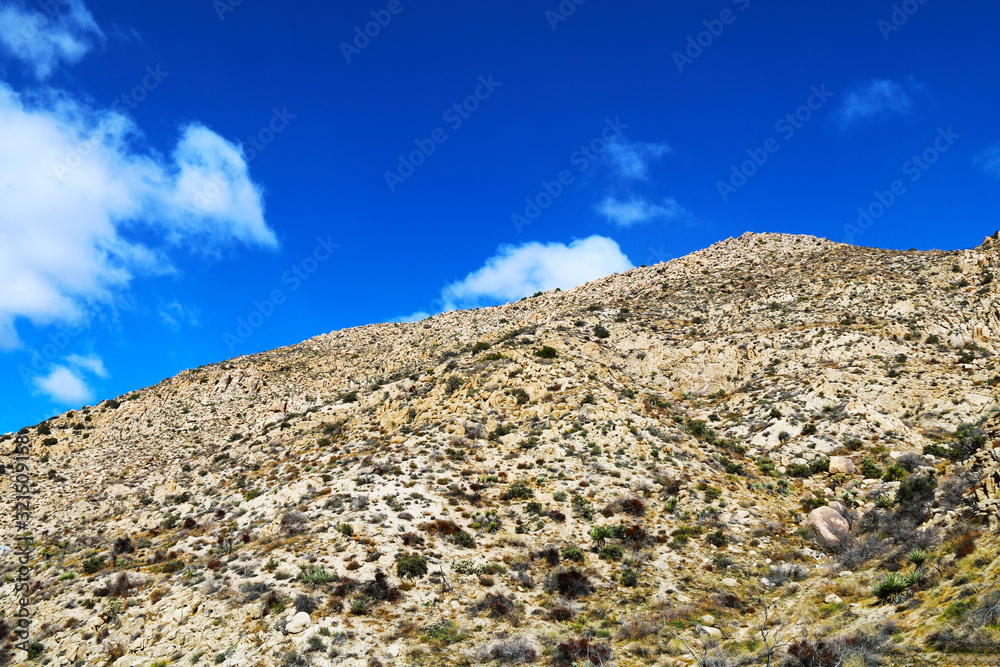 a rocky desert mountain against bright blue sky a rocky desert mountain against bright blue sky