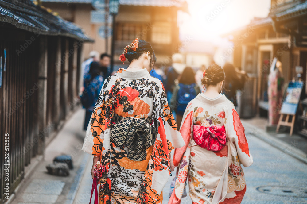 Young women wearing traditional Japanese Kimono  with colorful maple trees in autumn is famous in autumn color leaves and cherry blossom in spring, Kyoto, Japan.