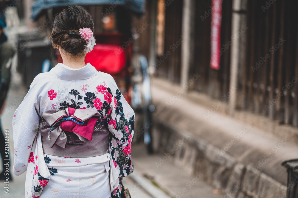 Young women wearing traditional Japanese Kimono  with colorful maple trees in autumn is famous in autumn color leaves and cherry blossom in spring, Kyoto, Japan.