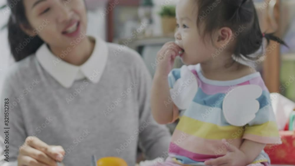 Asian parents Feeding the little daughter's lunch At the dining table in his own house Happily. Family happy moments. Asian parents Feeding the little daughter's lunch At the dining table in his own house Happily. Family happy moments.