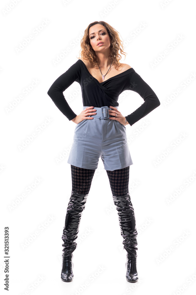Beautiful slim curly hair young woman fashion model posing with hands on hips in stylish clothes. Full body length isolated on white background. Beautiful slim curly hair young woman fashion model posing with hands on hips in stylish clothes. Full body length isolated on white background.