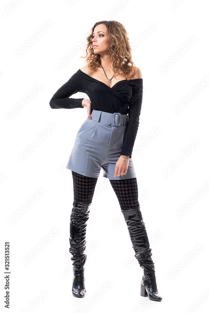 Confident young curly hair woman fashion model in elegant clothes with hand on hip looking away. Full body length isolated on white background. Confident young curly hair woman fashion model in elegant clothes with hand on hip looking away. Full body length isolated on white background.