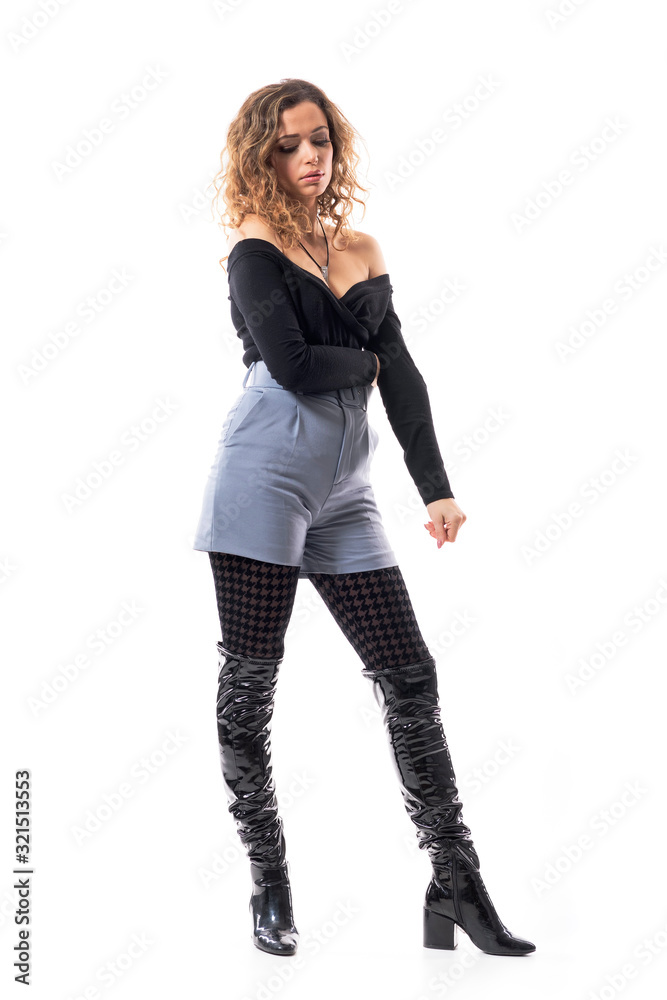 Worried sad fashionable young curly hair woman with folded arms looking down in disappointment. Full body length isolated on white background. Worried sad fashionable young curly hair woman with folded arms looking down in disappointment. Full body length isolated on white background.