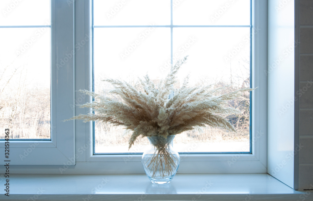 Plakat White window On the windowsill is a vase with dry flowers. Interior