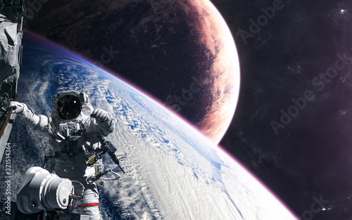 Astronaut in orbit of a planet somewhere in deep space. Science fiction. Elements of this image furnished by NASA