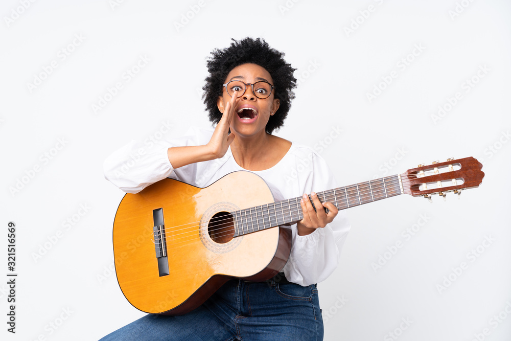 African american woman with guitar over isolated background shouting with mouth wide open