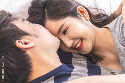 Lovely attractive young Asian couple man kiss forehead of happy woman with and hug in romantic moment. Warm heart marriage and lover bonding and relationship. Husband and wife in love photo concept.