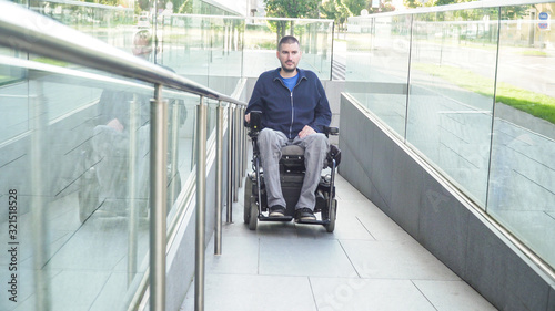Fotografie man on electric wheelchair using a ramp. Accessibility concept