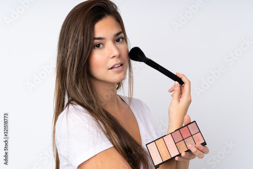 Teenager girl over isolated background with makeup palette