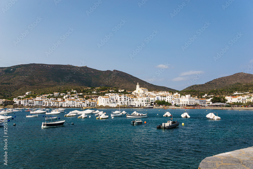 Little boats close to a white mediterranean village in a summer day