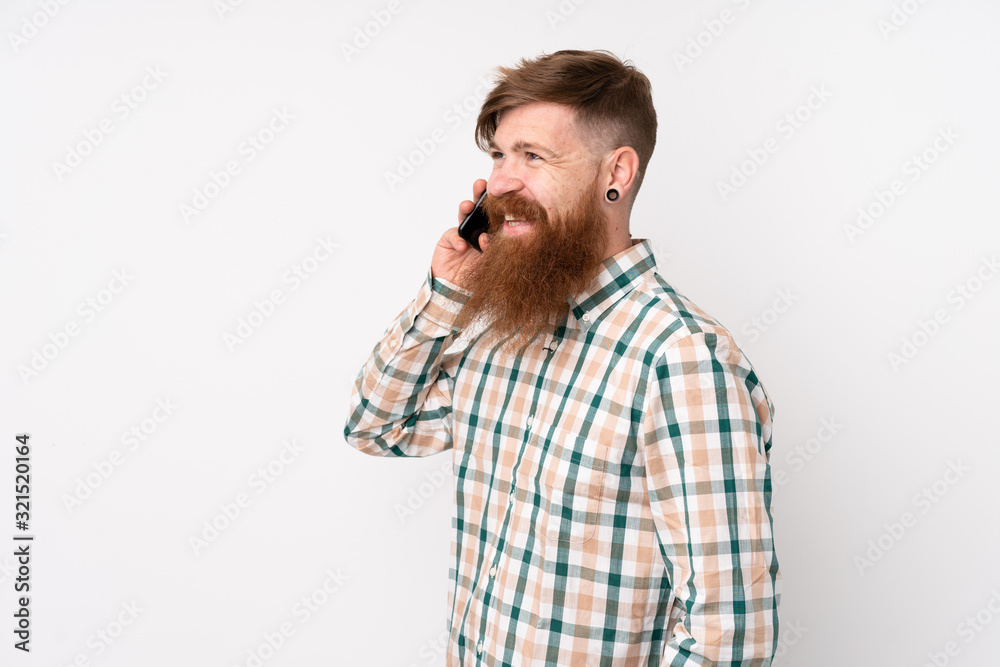 Redhead man with long beard over isolated white background keeping a conversation with the mobile phone Redhead man with long beard over isolated white background keeping a conversation with the mobile phone