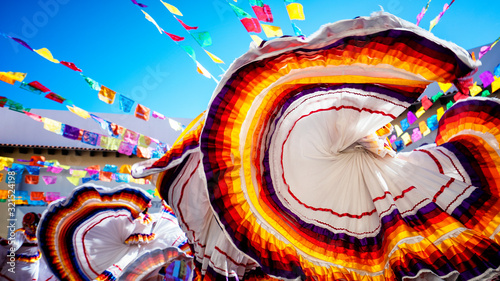 Traditional folklore dance in latin america. Beautiful colorful dress waving in the air.  photo