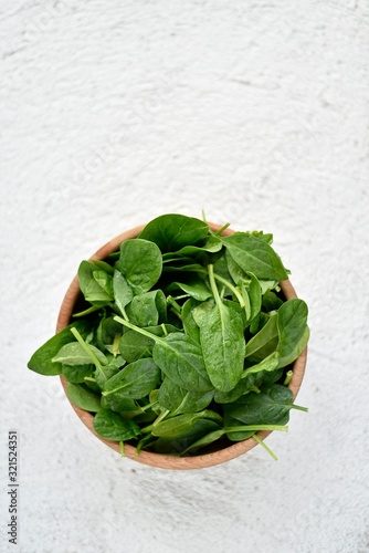 wooden bowl full of baby spinach