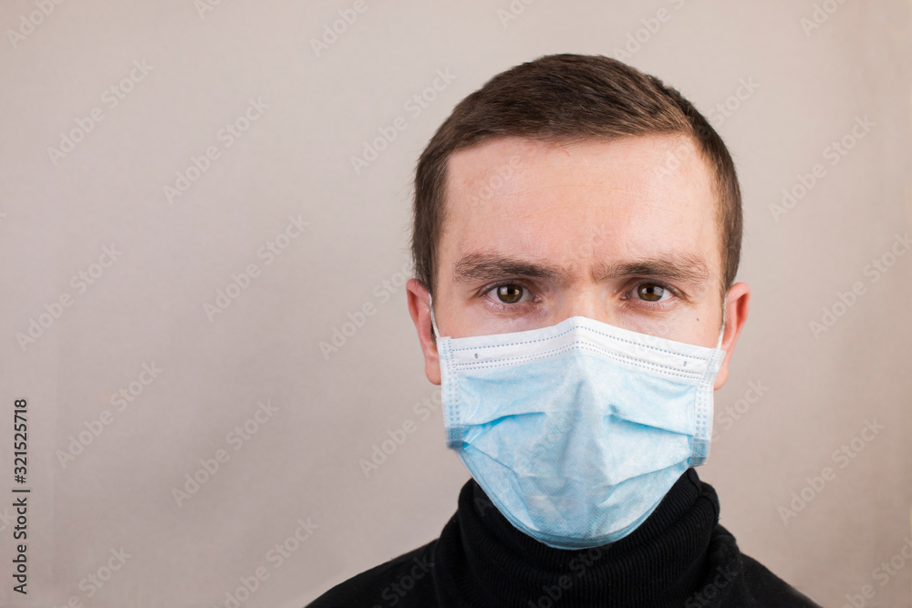 Guy in an antiviral mask, black turtleneck on a gray background Guy in an antiviral mask, black turtleneck on a gray background