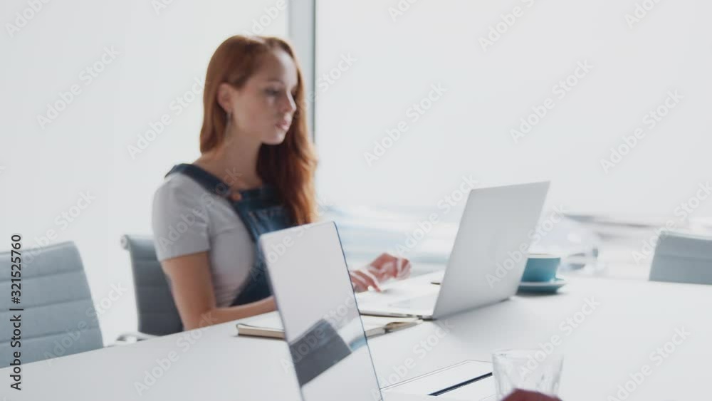 Pull Focus Shot Of Two Casually Dressed Young Businesswomen Working On Laptops And In Office Pull Focus Shot Of Two Casually Dressed Young Businesswomen Working On Laptops And In Office