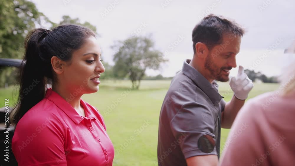 Group Of Male And Female Golfers Standing By Golf Buggy On Course And Choosing Clubs Group Of Male And Female Golfers Standing By Golf Buggy On Course And Choosing Clubs