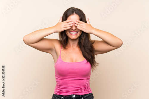 Young woman over isolated white background covering eyes by hands