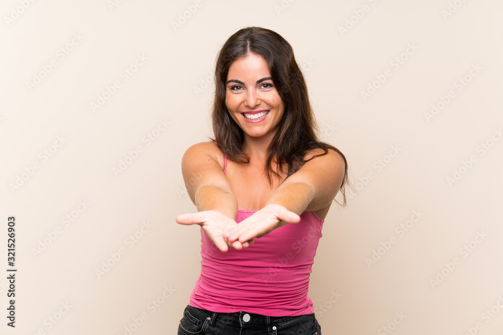 Young woman over isolated white background holding copyspace imaginary on the palm to insert an ad Young woman over isolated white background holding copyspace imaginary on the palm to insert an ad