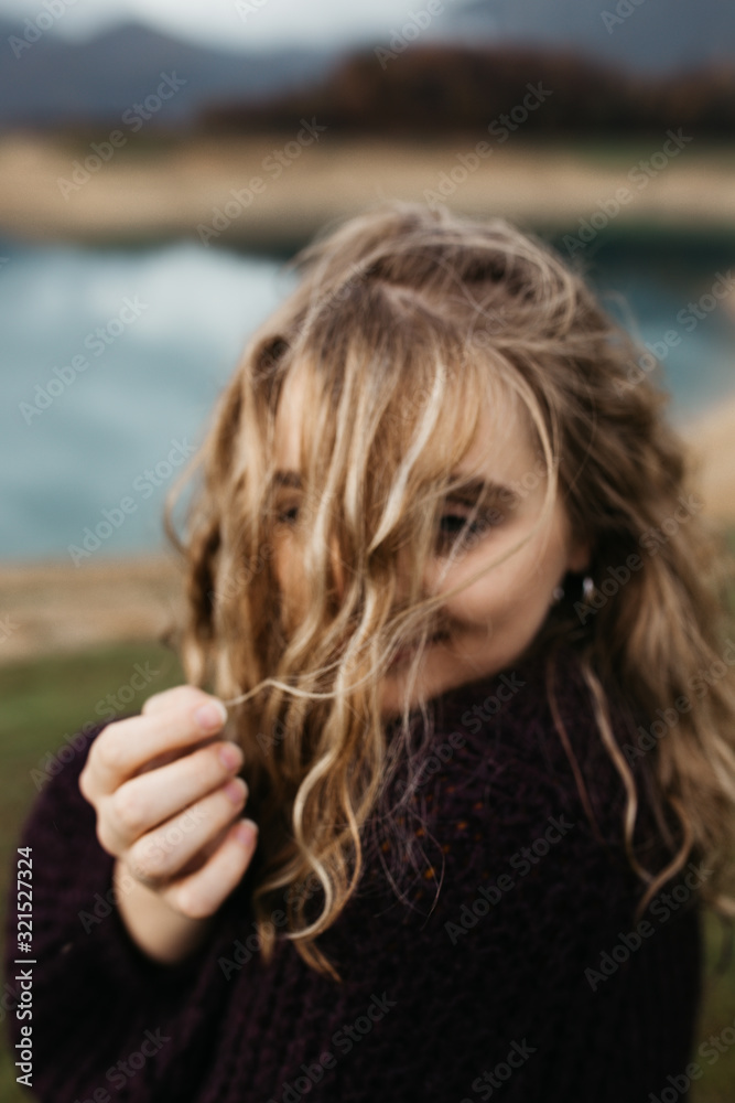 Naklejka premium Portrait of beautiful romantic woman standing near lake. She is smiling and enjoying her time. 