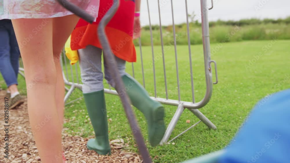 Group Of Excited Young Friends At Music Festival Carrying Camping Equipment Onto Site Group Of Excited Young Friends At Music Festival Carrying Camping Equipment Onto Site