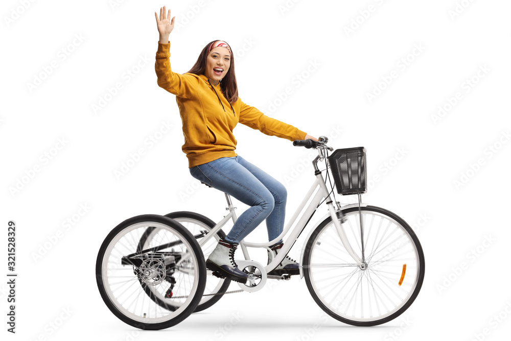 Cheerful young female riding a tricycle and waving at the camera Cheerful young female riding a tricycle and waving at the camera