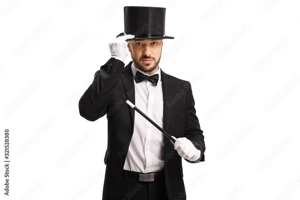 Magician with a magic wand holding his hat and looking at camera
