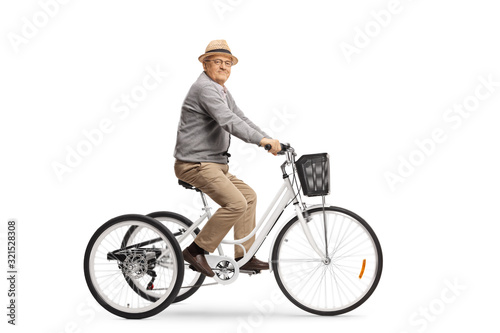 Elderly man riding a white tricycle and smiling at the camera