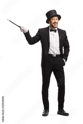 Foto Smiling happy magician pointing with a magic wand