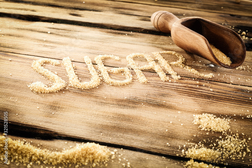 Brown sugar inscription with wooden table background and space for your decoration.