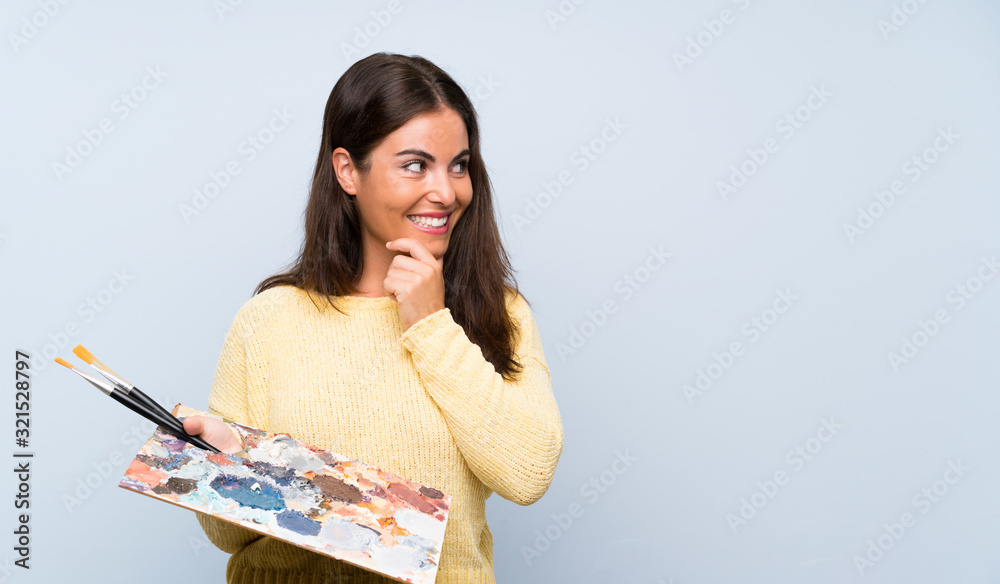 Young artist woman over isolated blue background thinking an idea and looking side Young artist woman over isolated blue background thinking an idea and looking side