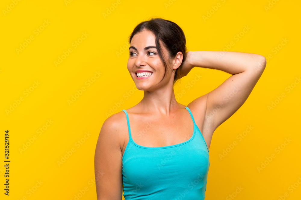 Young woman over isolated yellow background laughing Young woman over isolated yellow background laughing