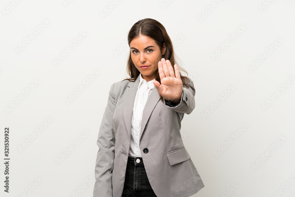 Young business woman over isolated white background making stop gesture with her hand Young business woman over isolated white background making stop gesture with her hand