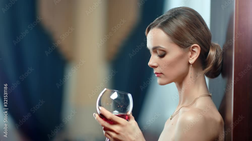 Portrait sensual lady bare body with glass of alcohol beverage. Wide shot on RED camera