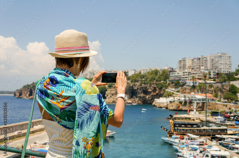 Woman on vacation, standing enjoy beautiful seascape looking forward to sea, sky and yacht