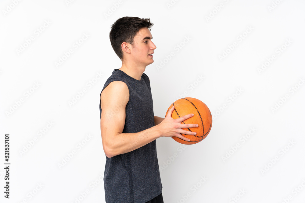 Handsome young basketball player man over isolated wall playing basketball